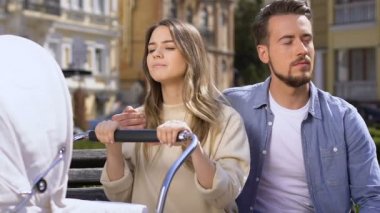 Uykulu çift parkta bebek arabası sallanan, deneyimsiz ebeveynler, ilk çocuk