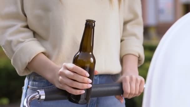 Onverantwoord moeder bier drinken, een wandeling met baby in het vervoer, verslaving — Stockvideo