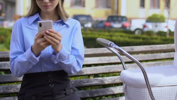 Mujer trabajando en el teléfono móvil mientras ve al bebé, elección entre la carrera y el niño — Vídeo de stock