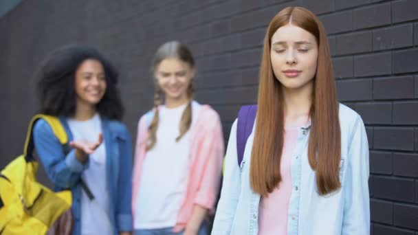 Hopeless bullying victim looking camera, female classmates discussing behind — Stock Video