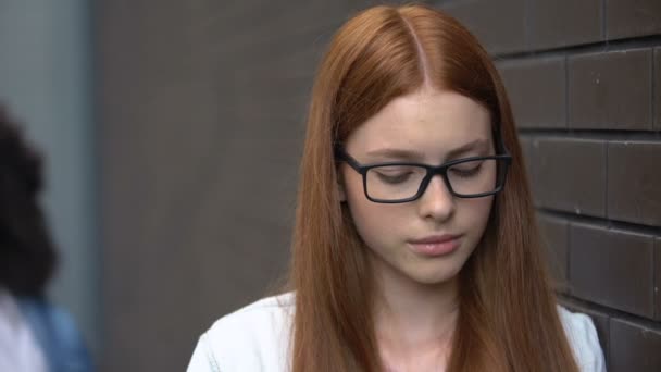 Depressed red-haired teenager eyeglasses suffering insulting classmate, conflict — Stock Video