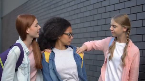 College students stopping frightened black teenager in school backyard, bullying — Stock Video