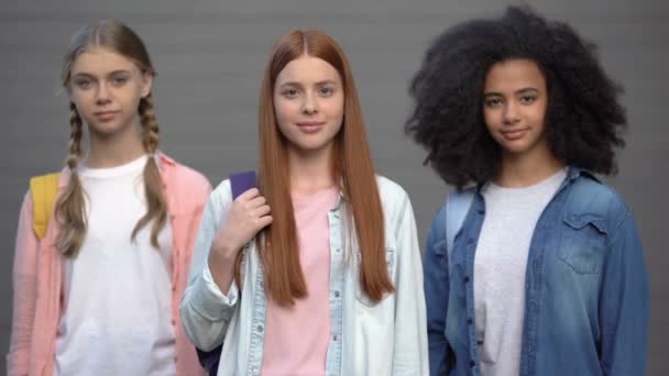 Adolescentes con bolsas de la escuela sonriendo entre sí, programa de intercambio de estudiantes — Vídeos de Stock