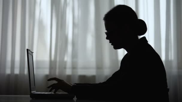 Silhuett av affärskvinna skriva på laptop, gör paus för att koncentrera sig — Stockvideo