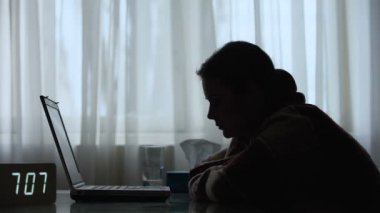 Yorgun öğrenci uykuya dalıyor, tüm gece boyunca dizüstü bilgisayarda diploma üzerinde çalışıyor