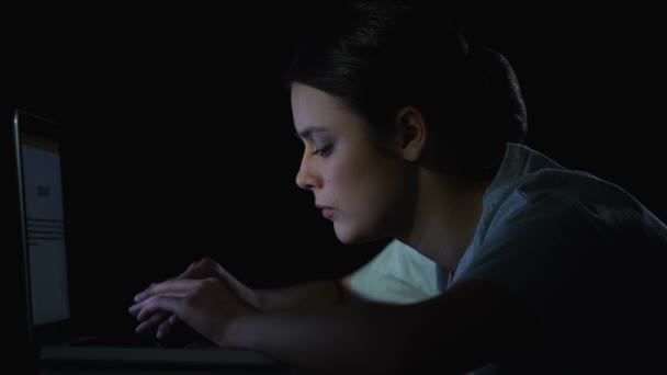 Κορίτσι προγραμματιστής δακτυλογραφεί στο laptop και χασμουριέται αργά τη νύχτα, δουλεύοντας στο πρόγραμμα — Αρχείο Βίντεο