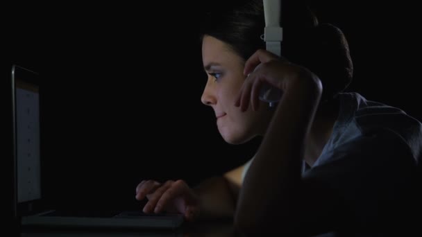 Chica joven escuchando música en auriculares desplazándose por las redes sociales en el ordenador portátil — Vídeos de Stock