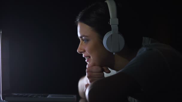 Adolescente em fones de ouvido sinceramente rindo assistindo engraçado programa de tv no laptop — Vídeo de Stock