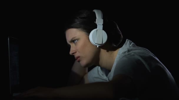 Tired woman taking off headphone and putting head on arms, exhausted night shift — Stock Video