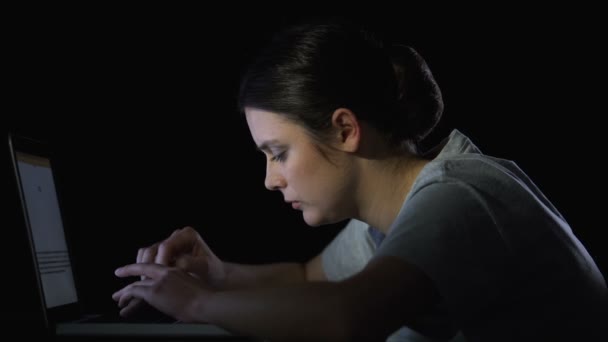 Студент печатает отчет на ноутбуке поздно ночью, устал от сложной домашней задачки — стоковое видео