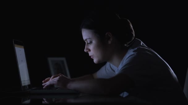 Señora escribiendo en el ordenador portátil en habitación oscura mirando la foto y sonriendo hija desaparecida — Vídeos de Stock