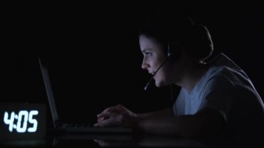 Gece geç saatlerde video oyunları oynayan kulaklık kadın oyuncu, bilgisayar bağımlılığı