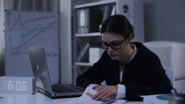 Memnun olmayan kadın bölüm başkanı grafiklere bakarak, para birimini kontrol ediyor