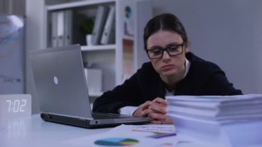 Depresif finans uzmanı belgelerin yığınına bakıyor, sefil hissediyor