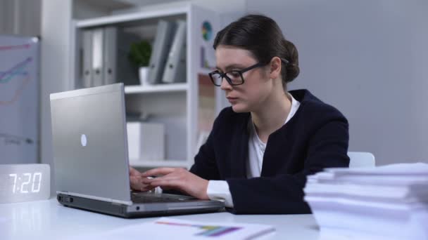 Mujer de negocios escribiendo en el ordenador portátil y sufriendo dolor de cabeza como resultado de la carga de trabajo — Vídeos de Stock