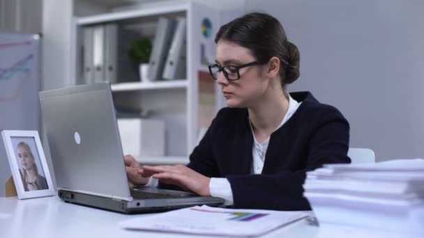 Kobieta pracownik biurowy zamknięcie laptopa i patrząc na dziewczynę zdjęcie zaginionej córki — Wideo stockowe