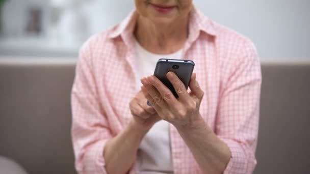 Mulher idosa sorrindo usando smartphone, aplicação para pessoas idosas, tecnologia — Vídeo de Stock