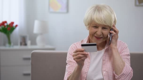Velha segurando cartão de crédito e telefone falando, programas bancários para pessoas idosas — Vídeo de Stock