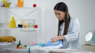 Ütü leme sırasında bluz üzerinde üzgün ev kadını yanan delik, deneyim eksikliği