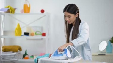 Sinirli ev hanımı demir temizlik sorunu ile yanmış bluz delik bakar