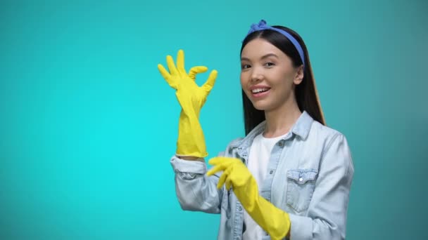 Beautiful housewife wearing gloves and showing ok gesture at camera, cleaning — Stock Video