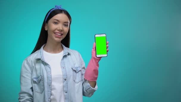 Girl in gloves pointing finger at smartphone with green screen, cleaning service — Stock Video