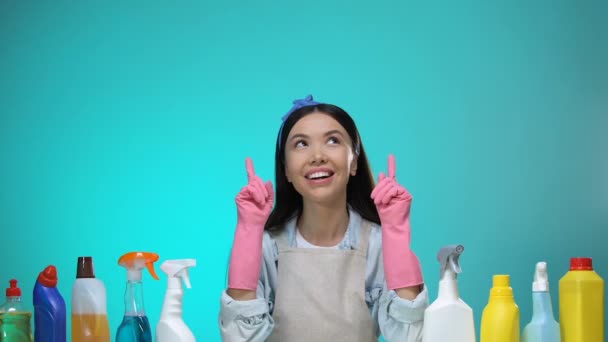 Веселая домохозяйка показывает пальцем вверх, стиральные порошки на стол концепции ведения домашнего хозяйства — стоковое видео