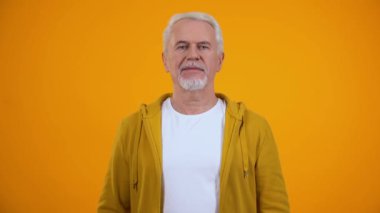 Mutlu üst düzey erkek ok jest gösteren ve kamera, yüksek emeklilik, kredi göz kırpma