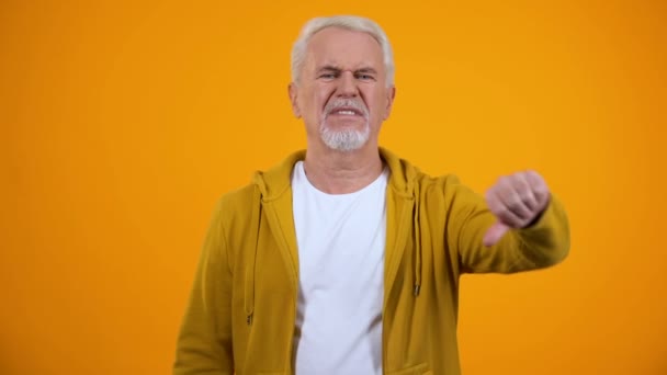 Homem idoso descontente mostrando gesto de polegar para baixo, desgosto, feedback negativo — Vídeo de Stock