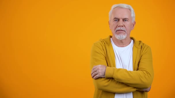 Erstaunter Rentner zeigt Wow-Geste vor orangefarbenem Hintergrund — Stockvideo
