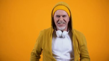Şık giysiler içinde neşeli yaşlı dj dolar notlar atma ve müzik dans