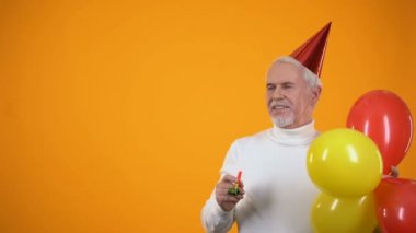 Renkli balonlar ile neşeli üst düzey adam parti üfleyici kullanarak, olay ajansı