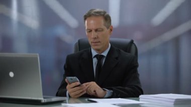 İşadamı dizüstü bilgisayar, teknolojileri ile işyerinde müşteri ile cep telefonu mesajlaşma