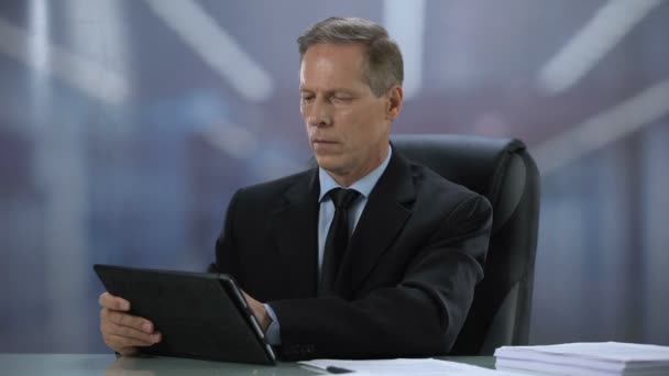 Ofis masasında tablet pc üzerinde çalışan kendinden emin erkek patron, online belgeler — Stok video