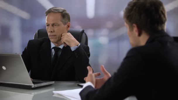 Arrendatario hombre desatento mirando portátil durante la entrevista de trabajo con el candidato masculino — Vídeos de Stock