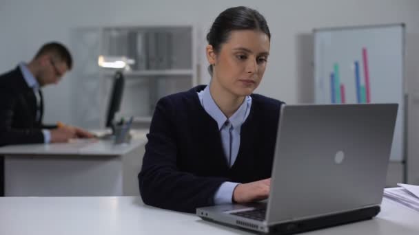 Gerente do sexo feminino digitando no laptop e sorrindo para a câmera, dia de trabalho em grande empresa — Vídeo de Stock