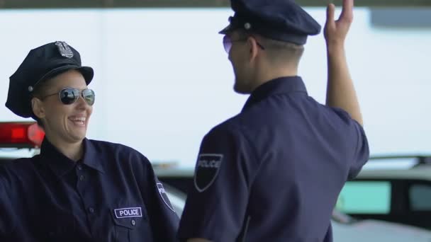 Χαμογελαστοί αστυνομικοί που δίνουν πέντε, πανηγυρίδα μέρα περιπολίας χωρίς εγκλήματα. — Αρχείο Βίντεο