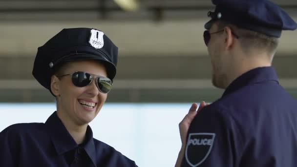 Партнери жіночої та чоловічої поліції сміються, роблять перерву під час міського патрулювання, відпочивають — стокове відео