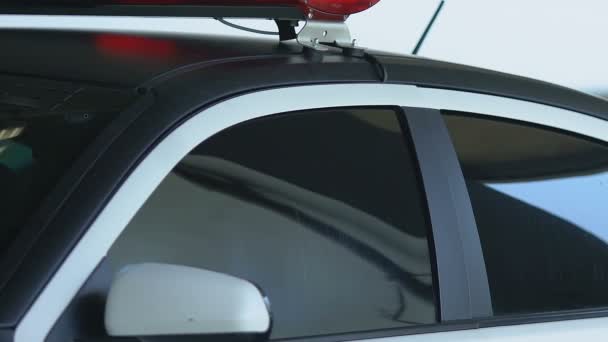 Policjant wychodzi z samochodu, aby sprawdzić połączenie alarmowe, patrolowanie ulic — Wideo stockowe