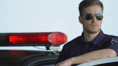 Araba yakınında duran güneş gözlüğü profesyonel polis memuru, ilçe güvenliği