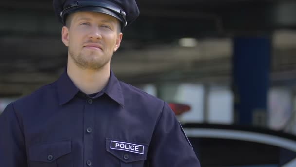 Giovane bel poliziotto sorridente, felice di servire per la sicurezza della città, reclutamento — Video Stock