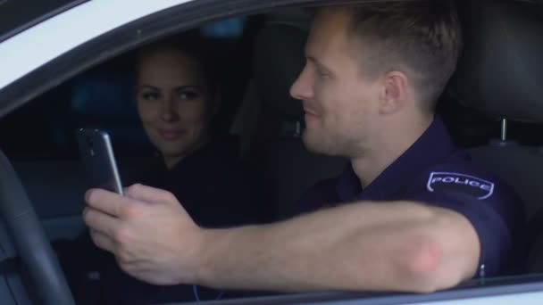 Policista kontroluje společenské sdělovací prostředky při hlídání s partnerem v autě, závislost — Stock video