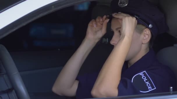 Mujer policía vistiendo sombrero de policía, mirando en el espejo sentado en el coche, feminidad — Vídeo de stock