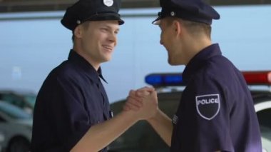 Erkek polis arkadaşları vardiya başlamadan önce birbirlerini selamlıyor, dostluk
