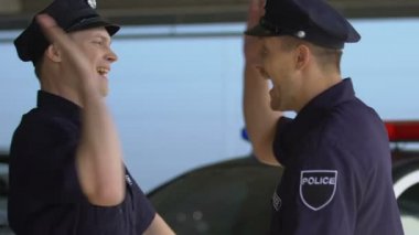 Neşeli polis memurları birbirlerine yüksek beş veren ve arabaya gidiyor