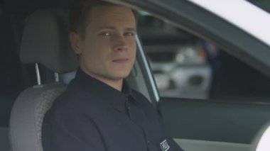 Dost polis memuru devriye arabasının sürücü koltuğunda oturan kameraya gülümseyerek