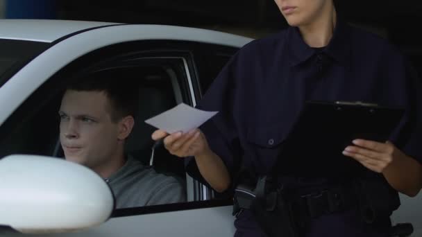 Патрульная выписывает штраф водителю за нарушение правил дорожного движения — стоковое видео