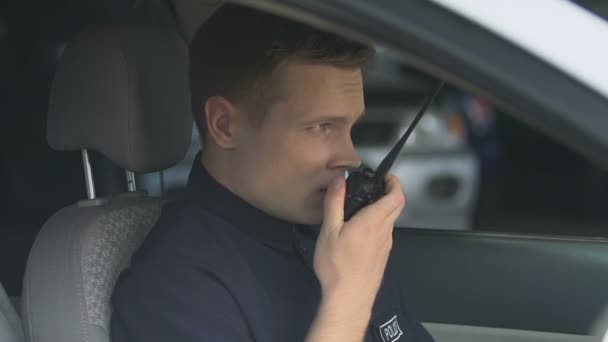 Patrolman přenášející informace pomocí obousměrnou vysílačky, čekající na instrukce — Stock video