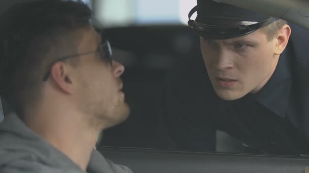Policista kontroluje řidičské povolení člověka v autě, policajt v pravidlech pro služební provoz — Stock video
