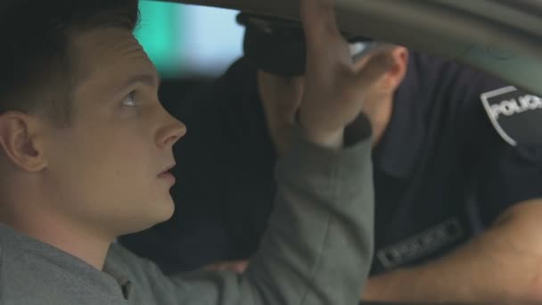 Поліцейський перевіряє документи про автомобіль нервового водія, підозрює про контрабанду — стокове відео